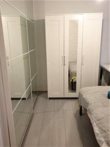 um quarto com armários brancos e uma porta de vidro em Private Room in a Shared House-Close to City & ANU-2 em Canberra