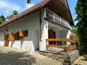 a white house with two benches on the porch at Parraghegy Apartman in Zalaszántó