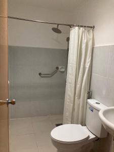 y baño con ducha, aseo y lavamanos. en Demiren Hotel, en Cagayan de Oro