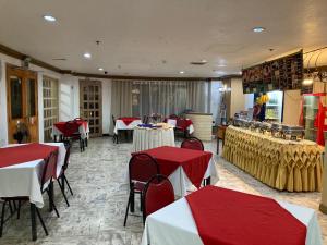a restaurant with red and white tables and chairs at Demiren Hotel in Cagayan de Oro