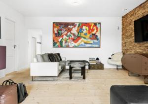 uma sala de estar com um sofá e uma pintura na parede em Aarhus - cozy house, 10 min from city center em Aarhus