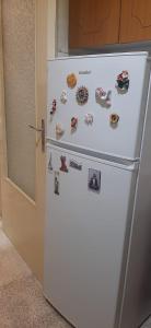 a white refrigerator with magnets and pictures on it at Casa della nonna Marina in Floridia +4 photos