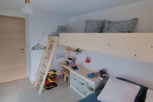 a room with a loft bed with a desk and a desk at Appart 8 personnes piscine sauna pied des pistes in Le Dévoluy