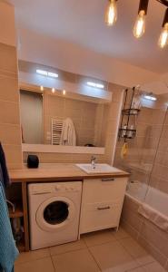 a bathroom with a washing machine and a sink at Appart 8 personnes piscine sauna pied des pistes in Le Dévoluy