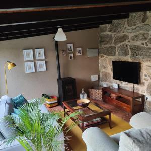a living room with a couch and a stone fireplace at Casa Ribadil in Crecíente
