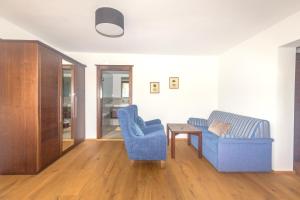 uma sala de estar com duas cadeiras azuis e uma mesa em Hotel Stadler am Attersee em Unterach am Attersee