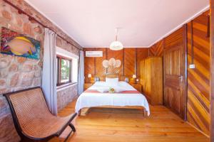 a bedroom with a bed and a chair in it at La Saline in Anse Possession