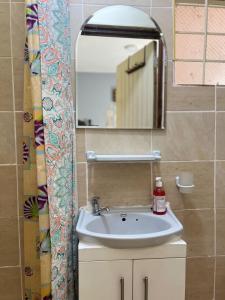 W łazience znajduje się umywalka i lustro. w obiekcie Private room in Townhouse, Kilimani. w mieście Nairobi
