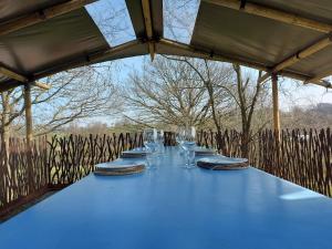 a blue table with glasses and plates on it at Le Bunker du Houyeux in Herve
