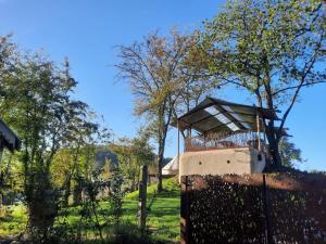 a building on top of a field with trees at Le Bunker du Houyeux in Herve