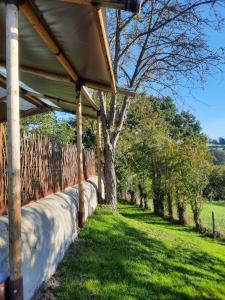 a porch of a house with a fence and trees at Le Bunker du Houyeux in Herve