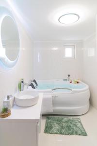 La salle de bains blanche est pourvue d'une baignoire et d'un lavabo. dans l'établissement Eternity Apartmanház, à Keszthely