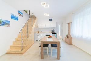 a kitchen and dining room with a table and stairs at Eternity Apartmanház in Keszthely
