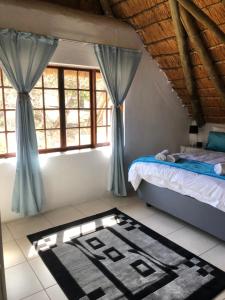 ネルスプロイトにあるVilla Jullienne - A Home Away From Home - Unit 5のベッドルーム1室(ベッド1台、窓、ラグ付)