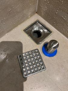 un cuenco de metal para perros y un drenaje en el suelo en Open Room Hotel, en Tamsui
