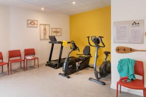 a gym with exercise bikes and chairs in a room at DOMITYS LES SALINES in Cherbourg en Cotentin