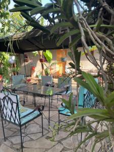 un patio con mesa y sillas bajo una sombrilla en Livingstone Legacy Lodge, en Arusha