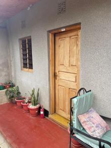 a wooden door with a row of plants and a chair at Livingstone Legacy Lodge in Arusha