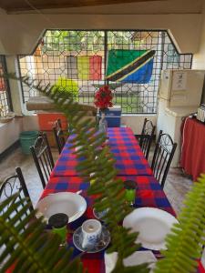 una mesa con platos en una habitación con vidriera en Livingstone Legacy Lodge, en Arusha