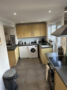 a kitchen with a washer and dryer in it at Modern 3 bed house 2 parking spaces contractors welcome in Stevenage