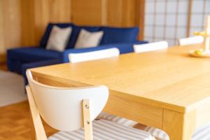 a wooden table with white chairs and a blue couch at Furano Yukinko House in Furano +14 photos