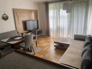 a living room with a table and a couch at Wohnhaus City Süd in Herzogsdorf +25 photos