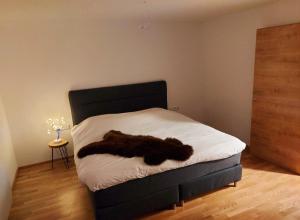 a bedroom with a bed with a black blanket on it at Ski & Alps Tamsweg in Sauerfeld