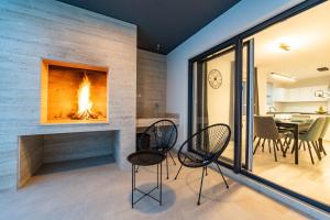 a living room with two chairs and a fireplace at Kuća za odmor Marita in Privlaka