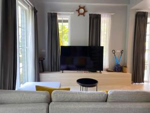 ein Wohnzimmer mit einem Sofa und einem Flachbild-TV in der Unterkunft Crown View Beach Resort Koh Chang in Ko Chang