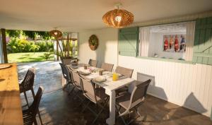 a dining room with a table and some chairs at Jolie CASE CREOLE, LAGON à pied, Jardin in Saint-Gilles les Bains