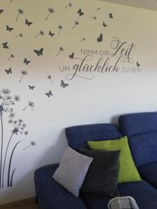 um quarto com um decalque de parede de dente-de-leão com borboletas em Schnetter Hummel, Apartment 1 em Masserberg