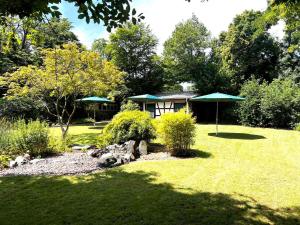 ogród z domem i zielonym parasolem w obiekcie Altes Forsthaus Boppard w mieście Boppard