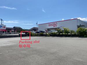 a parking lot with a parking sign in front of a building at 富士吉田たまきや in Fujiyoshida