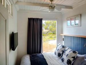 a bedroom with a bed and a window at Slow Track Farm in Baardskeerdersbos
