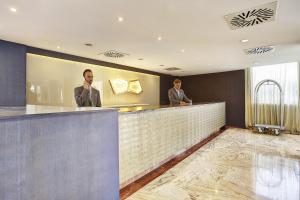 two men standing at a bar in a restaurant at Grupotel Acapulco Playa - Adults Only in Playa de Palma