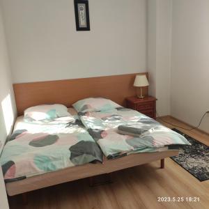 ein Schlafzimmer mit einem Bett mit einem Kopfteil aus Holz in der Unterkunft Apartament pod Lipą in Kłodzko