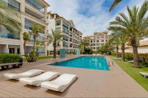 basen z leżakami obok budynku w obiekcie Guardamar Hill Resort Spa w mieście El Moncayo