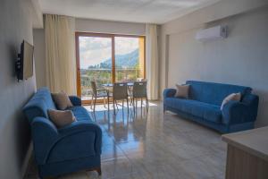 ein Wohnzimmer mit 2 blauen Sofas und einem Tisch in der Unterkunft Olive Tree Apart Hotel in Muğla