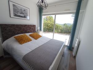Schlafzimmer mit einem Bett und einem großen Fenster in der Unterkunft Villa26 in Montauroux
