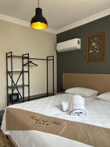 een slaapkamer met een bed met twee handdoeken erop bij ReynaBe Boutique Hotel in Dikili