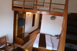 Cette chambre comprend 2 lits superposés et une table. dans l'établissement The Abhinandan, à Mussoorie