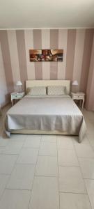 um quarto com uma cama grande e duas mesas em Casa del Mare em Alghero
