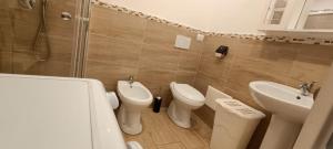 uma casa de banho com 2 WC, um lavatório e um chuveiro em Casa del Mare em Alghero