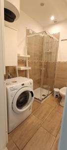 uma máquina de lavar roupa na casa de banho com um chuveiro em Casa del Mare em Alghero