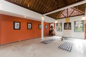 Nawa Sakti Resort في أوبود: غرفة فارغة بجدران برتقالية وسجادات بيضاء وسوداء