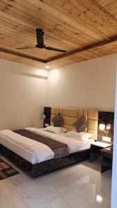 究希瑪斯的住宿－Jai Bajrangi Guest House，一间卧室设有一张大床和木制天花板