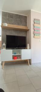 uma sala de estar com um centro de entretenimento branco com uma televisão em Casa del Mare em Alghero