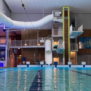 a large swimming pool with a water slide at Kvåstunet in Lyngdal