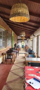 a room with tables and chairs and a large ceiling at SHADOW MASK BUNGALOW in Pattipola