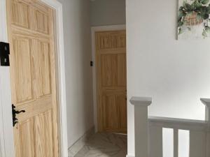 an empty hallway with a wooden door in a room at Peaceful Home in Surbiton, Surrey, Greater London- Free parking in Surbiton